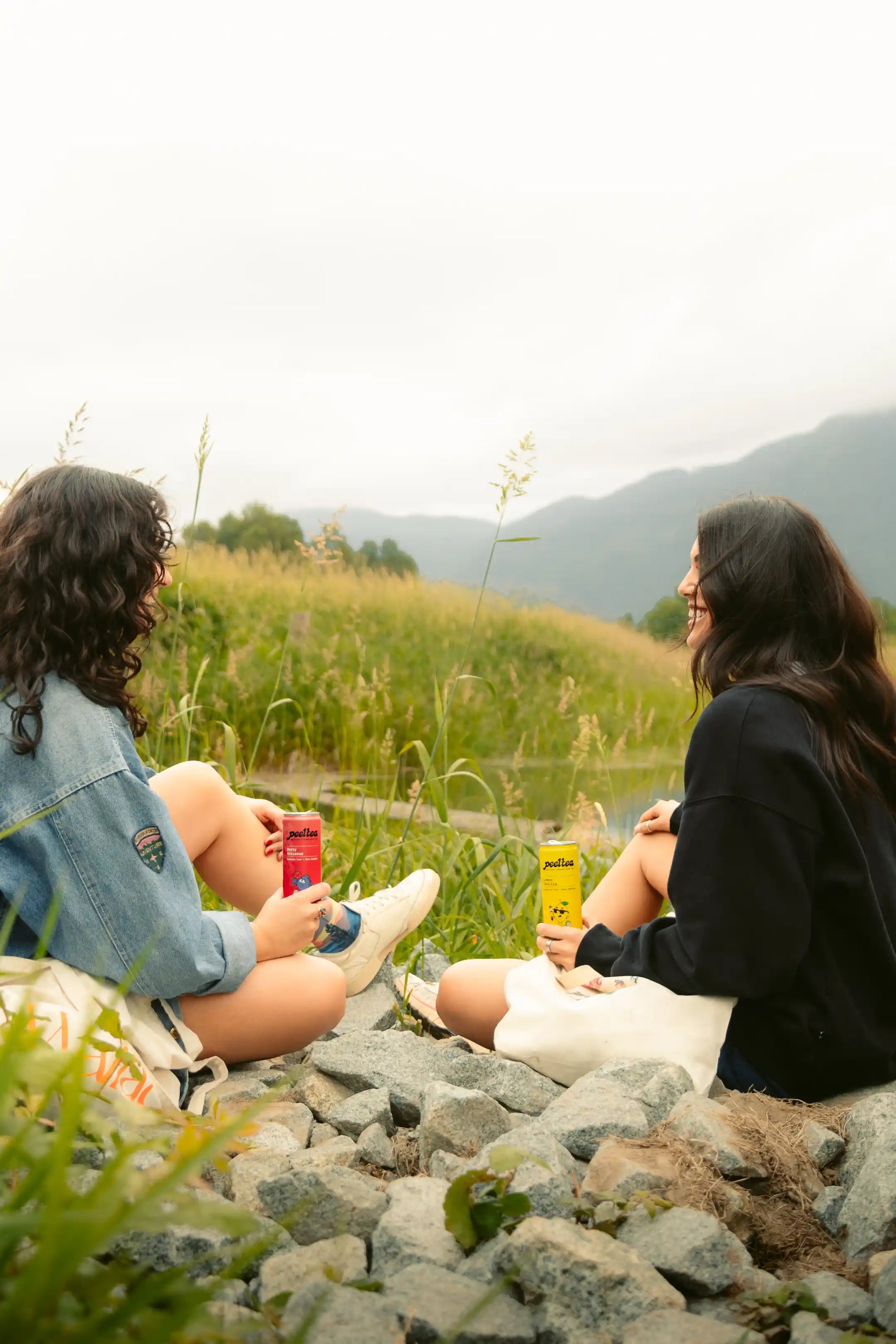 Two friends enjoying PeelTea nutrient-infused cold tea as a healthy drink choice outdoors.