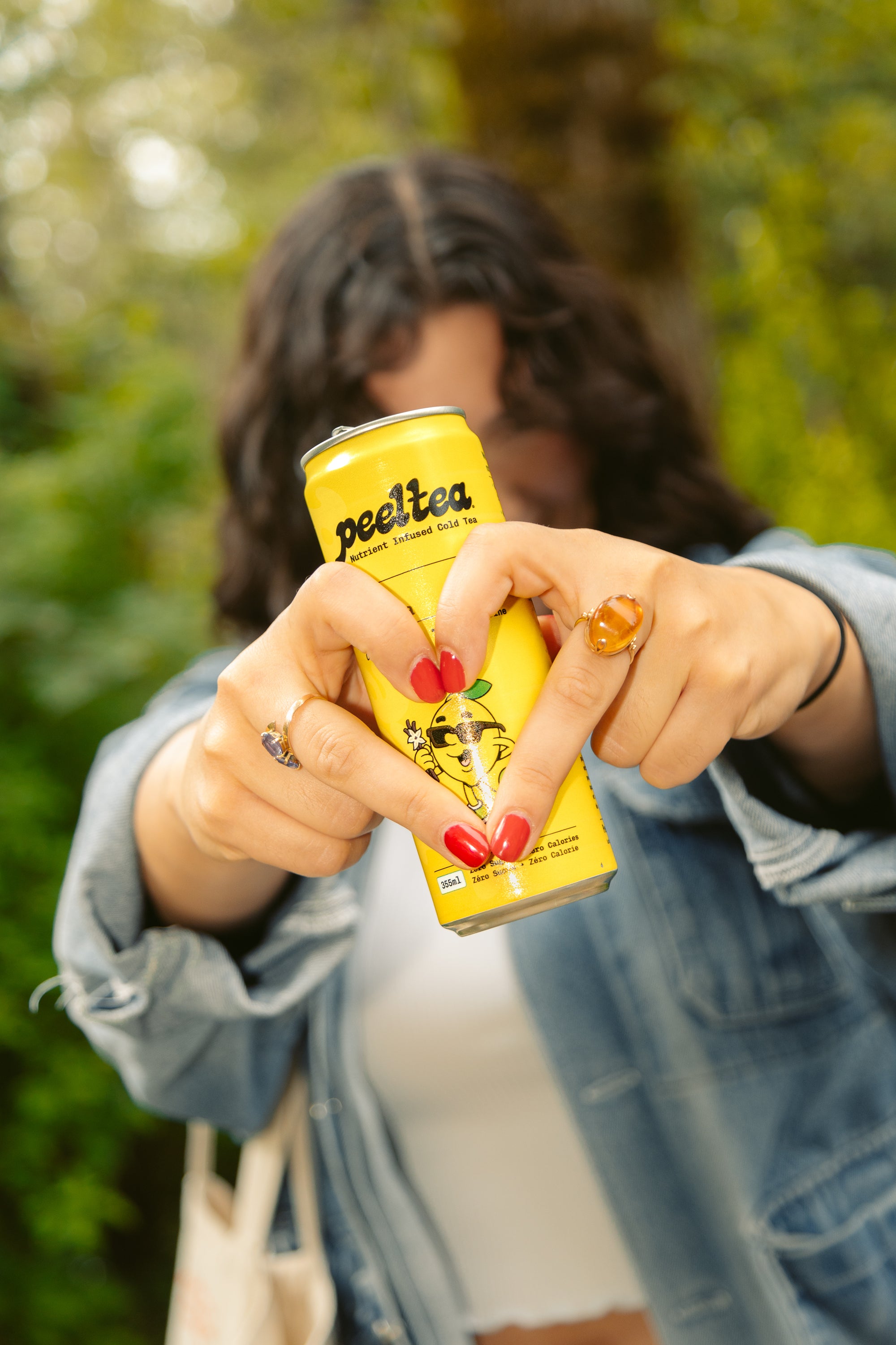 Woman making hand hearts to show love for PeelTea Lemon Vanilla nutrient-infused cold tea.