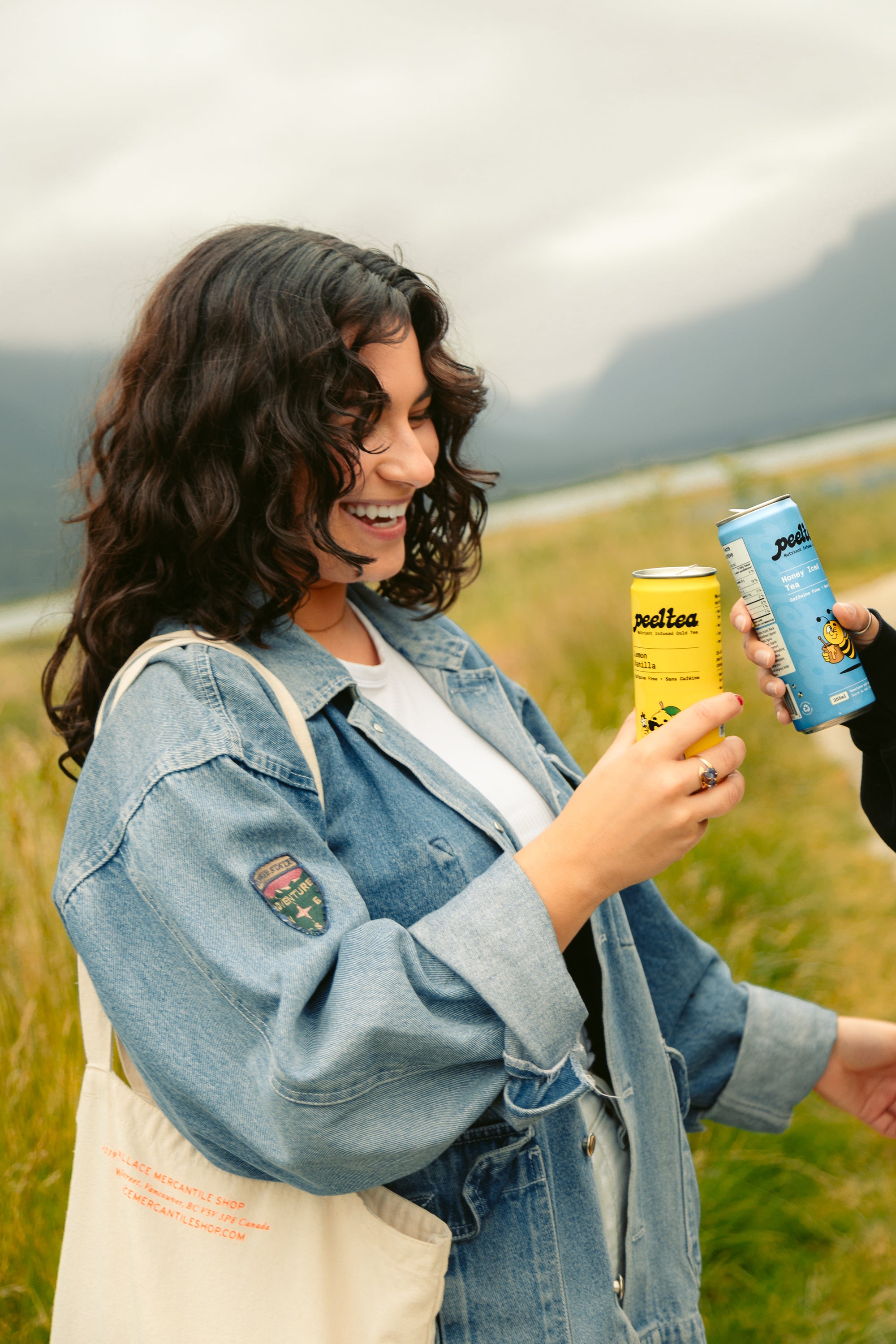 Smiling woman laughing outside while enjoying PeelTea nutrient-infused cold tea.