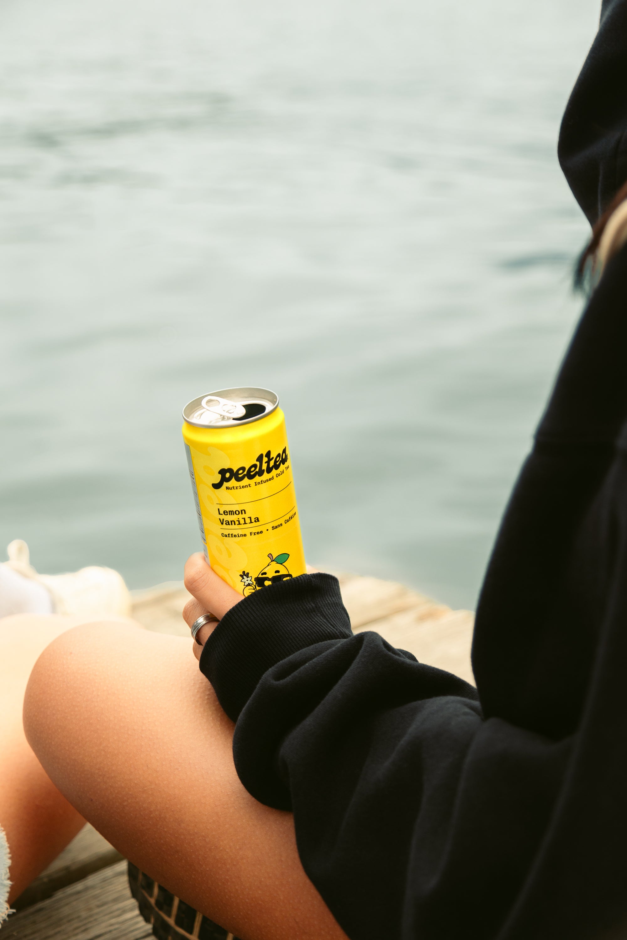 PeelTea Lemon Vanilla nutrient-infused cold tea being enjoyed by a lake as a healthy summer drink